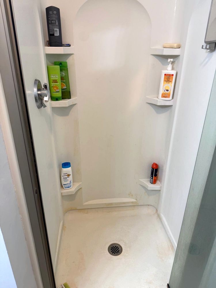 Shower with rust and grime stains before cleaning